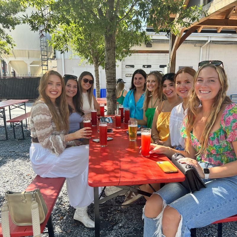 group of girls sitting at a table and having drinks at athens brewery tours